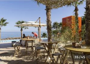 a person sitting at tables on the beach at Higuerón Prestige homes in Fuengirola
