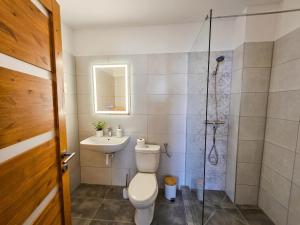 a bathroom with a toilet and a sink and a shower at Templomdomb Apartmanház in Tapolca +13 photos