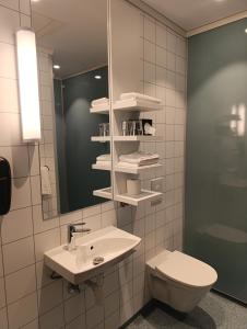 a bathroom with a sink and a toilet and a mirror at Hótel Laxá in Myvatn +40 photos