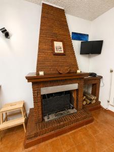 a brick fireplace in a living room with a tv at Il Focolare in Subiaco