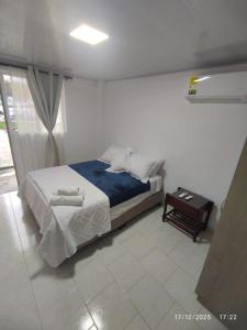a bedroom with a bed with two towels on it at Las Bailarinas Hotel Campestre in Montenegro