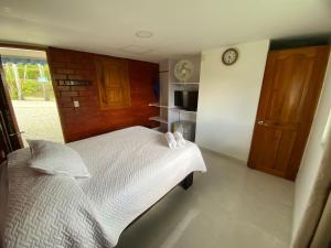 a bedroom with a bed and a clock on the wall at Las Bailarinas Hotel Campestre in Montenegro