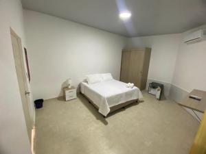 a bedroom with a white bed in a room at Las Bailarinas Hotel Campestre in Montenegro