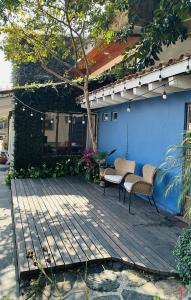 a patio with two chairs and a blue house at Sierra Central By Chic Hotel Group in Tepoztlán