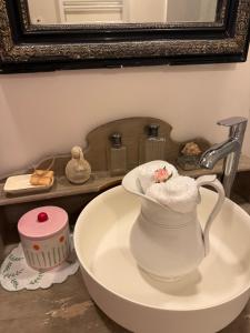 a white vase sitting on a sink in a bathroom at La vallée des grottes in Saint-Germain-sur-Vienne +51 photos