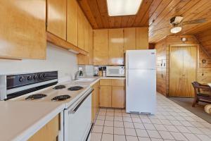 a kitchen with a white refrigerator and wooden cabinets at Chalet #17 in Stevensville