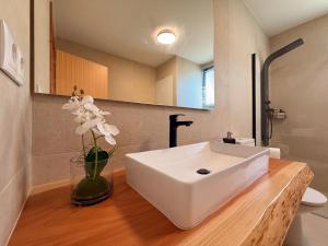 a bathroom with a white sink and a vase with flowers at Terra Vivaz - Porto Bay Formosa in Porto Formoso +32 photos