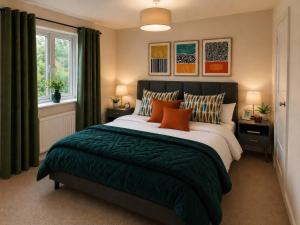 ein Schlafzimmer mit einem großen Bett und orangefarbenen Kissen in der Unterkunft Haregate House in Leek