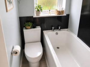 ein Badezimmer mit weißer Toilette und Badewanne in der Unterkunft Haregate House in Leek