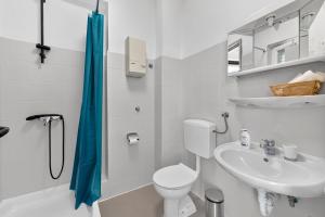 a white bathroom with a toilet and a sink at Room Blue View in Mlini