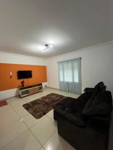 a living room with a couch and a flat screen tv at Casa Carregosa in São Roque