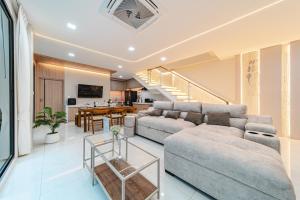 a living room with a couch and a table at Serene Pool Villa Pattaya 2 in Pattaya