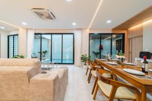 a living room with a couch and a table with chairs at Serene Pool Villa Pattaya 2 in Pattaya