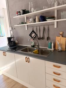 a kitchen with white cabinets and a sink at Kyrkåsen in Borgvik +8 photos