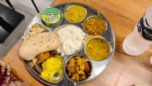 a plate of food with different types of food on a table at Sri Narayan Home Stay in Ayodhya +24 photos