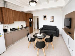 a kitchen and a living room with a table and chairs at Departamentos Centro in San Juan