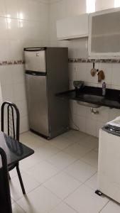 a kitchen with a stainless steel refrigerator and a table at Jabutiana casas Mobiliadas in Aracaju