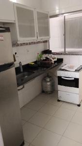 a kitchen with a stove and a sink and a refrigerator at Jabutiana casas Mobiliadas in Aracaju +8 photos