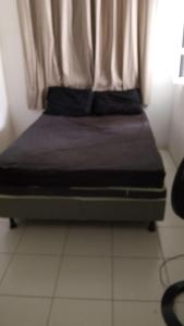 a bed sitting in a room with a window at Jabutiana casas Mobiliadas in Aracaju