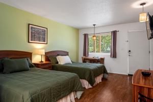 a hotel room with two beds and a window at Trailhead Lodge in Eureka Springs +6 photos