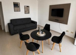 a living room with a table and chairs and a couch at Departamentos Centro in San Juan