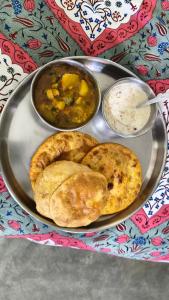 a plate of food with two pies and a bowl of rice at Sri Narayan Home Stay in Ayodhya