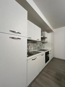 a white kitchen with a sink and a stove at Nova Stay in Rome