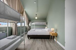 a bedroom with two bunk beds and a table at ASKA Hraun in Hafnarfjörður