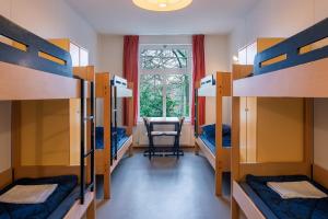 a dorm room with bunk beds and a desk at Stayokay Hostel Arnhem in Arnhem +29 photos