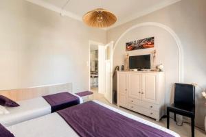 a bedroom with a bed and a flat screen tv at Au Moulin d'Or in Lille