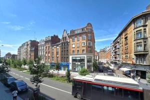 a bus driving down a city street with buildings at Au Moulin d'Or in Lille