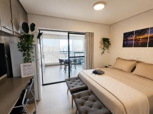 a bedroom with a large bed and a balcony at Studio Pôr do Sol - Garagem - Piscina - Anhembi in São Paulo +23 photos