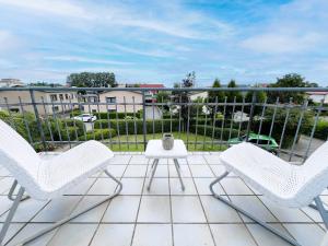 a patio with three chairs and a table on a balcony at Ferienwohnung Ostseeglück in der Villa Marie in Kühlungsborn