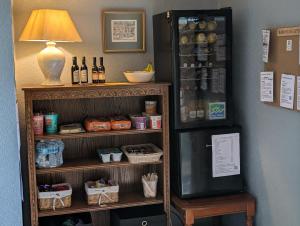 a shelf with bottles of wine and a refrigerator at Bossington Bunkhouse in Minehead +12 photos