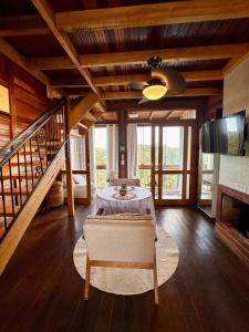 a living room with a table and a staircase at Chalé dos Manacás Duplex in Venda Nova do Imigrante