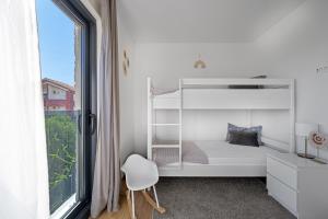 a bedroom with a white bunk bed and a window at Boho Beach House Srima in Srima +35 photos