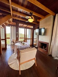 a living room with a table and a fireplace at Chalé dos Manacás Duplex in Venda Nova do Imigrante +28 photos