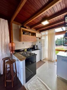 a kitchen with a stove and a counter top at Chalé dos Manacás Duplex in Venda Nova do Imigrante