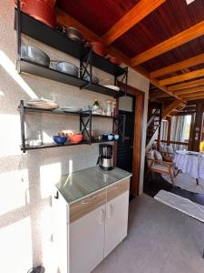 a kitchen with a counter and a table with dishes at Chalé dos Manacás Duplex in Venda Nova do Imigrante