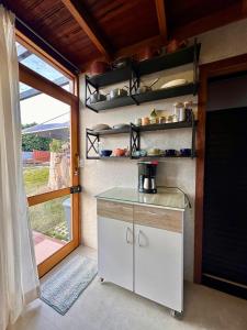 a kitchen with a counter and a door with a window at Chalé dos Manacás Duplex in Venda Nova do Imigrante