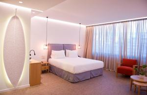 a hotel room with a large bed and a large window at NLH FIX | Neighborhood Lifestyle Hotels in Athens