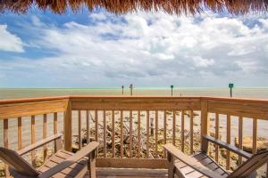 a deck with chairs and a view of the beach at Keys Waterfront Condo with Beach Pool Sunset Views in Tavernier