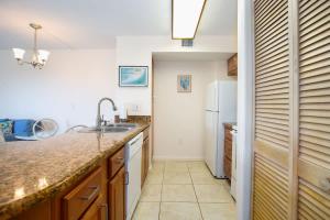 a kitchen with a sink and a refrigerator at Keys Waterfront Condo with Beach Pool Sunset Views in Tavernier