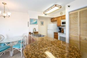 a kitchen with a counter top and a table at Keys Waterfront Condo with Beach Pool Sunset Views in Tavernier