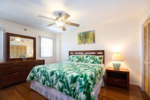 a bedroom with a bed and a ceiling fan at Keys Waterfront Condo with Beach Pool Sunset Views in Tavernier +32 photos
