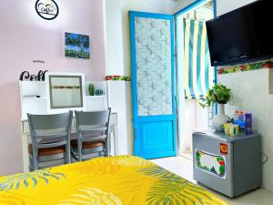 a bedroom with a yellow bed and a blue door at Ngõ Saigon Homestay in Ho Chi Minh City