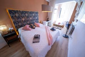 a bedroom with a bed with white sheets and pink pillows at Casa Jardin Huesca Ciudad in Huesca +1 photo