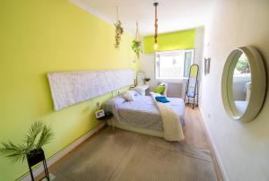 a bedroom with yellow walls and a bed and a mirror at Casa Jardin Huesca Ciudad in Huesca