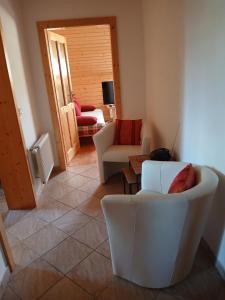 a living room with white chairs and a couch at Enzianhütte Gerlitzen Kanzelhöhe in Kanzelhöhe