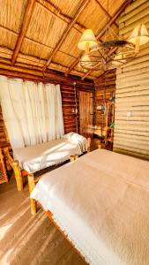 a room with two beds in a log cabin at Habitacion en Cabañas Bella vista in Bella Vista